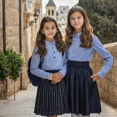 Firefly 2 young israeli girls, smiling, wearing a backpack brown hair, wearing a navy pleated skirt,