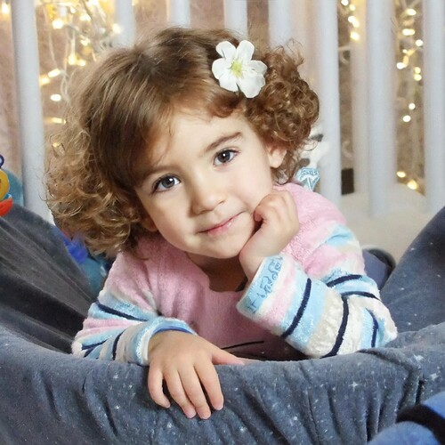 Firefly an Israeli little girl with short, curly, dark brown hair and big bright brown eyes, wearing