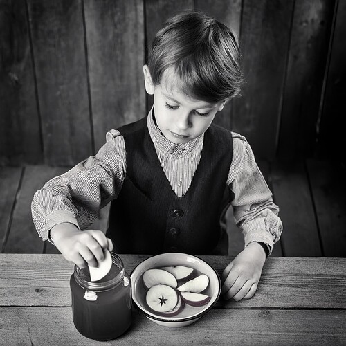 Firefly vintage photography of little boy dipping sliced apple in honey jar, top angle, vintage phot